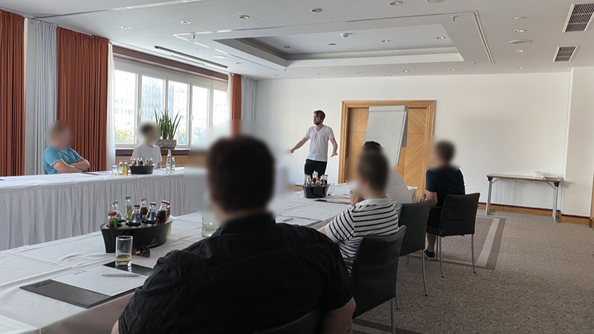 Andreas Lorenz coacht eine Gruppe von Teilnehmern in einem Seminarraum