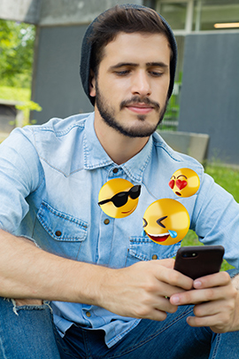 Mann mit Handy sendet Emojis