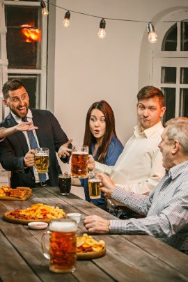 Gruppe von Freunden sitzt zusammen bei Fastfood und Bier