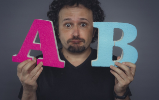 Mann mit fragendem Blick zeigt die Buchstaben A und B