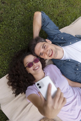 Mann und Frau schauen lachend aufs Handy