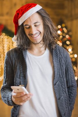Mann mit Handy liest Nachricht von Ex-Freundin zu Weihnachten