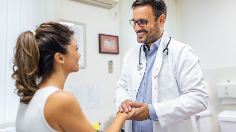 Verliebter Arzt hält Hand seines weiblichen Patienten