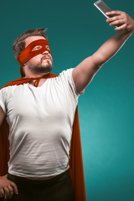 Mann im Superhelden-Kostüm macht Selfie