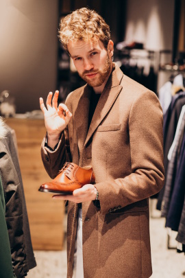 Mann im Bekleidungsgeschäft hält Schuh in der Hand