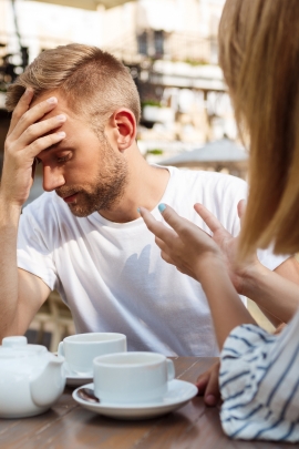 Mann schaut genervt, weil Freundin streitet