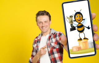 Mann zeigt Handy mit Gewinner-Biene im Display