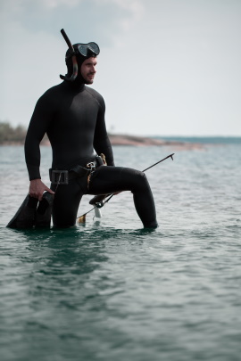 Taucher kniet im seichten Wasser