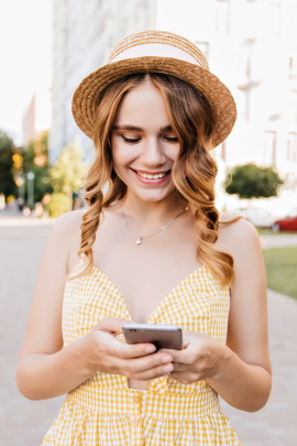 Lächelnde Frau schaut sich Dating-Profil am Handy an