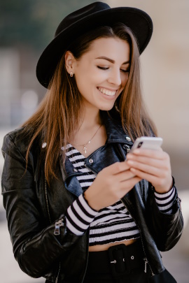 Frau schaut lächelnd aufs Smartphone