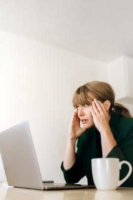 Frau sitzt gestresst vor ihrem Laptop