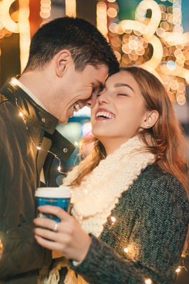 Paar trinkt Glühwein auf dem Weihnachtsmarkt und flirtet
