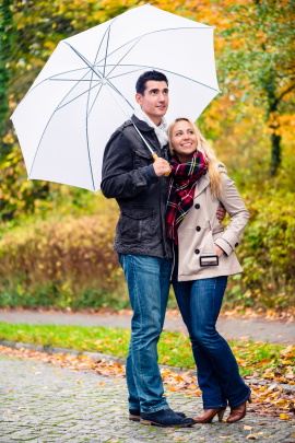 Paar mit Regenschirm macht Spaziergang im Herbst
