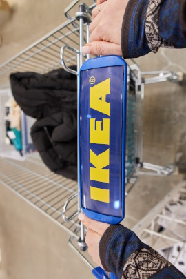 Frau schiebt einen Einkaufswagen von IKEA