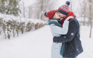 Paar beim Date im Winter küsst sich im Schnee