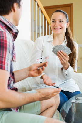 Junges Paar spielt Karten im Wohnzimmer