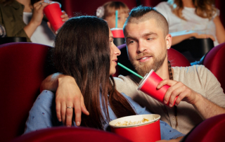 Verliebtes Paar sitzt im Kinosaal mit Popcorn und Cola