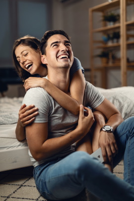 Mann und Frau lachen beim Date zuhause