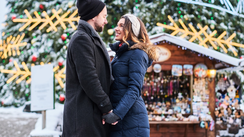 Glückliches Paar hält Händchen auf dem Weihnachtsmarkt