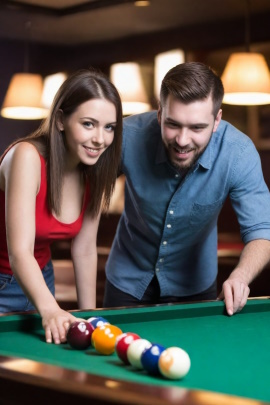 Mann und Frau spielen fröhlich Billard in der Kneipe