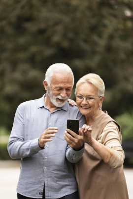 Zwei Senioren schauen begeistert aufs Handy