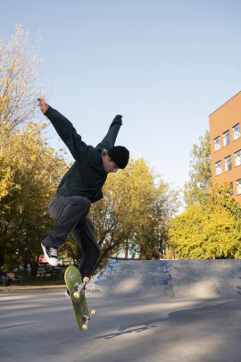 Mann macht beim Fotoshooting einen Sprung auf dem Skateboard