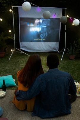 Mann überrascht Frau mit einem Outdoor Filmabend