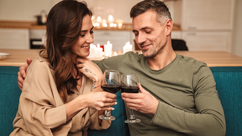 Mann und Frau mit Rotwein führen Gespräch auf der Couch
