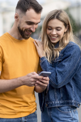 Mann und Frau in der Stadt schauen gemeinsam aufs Handy