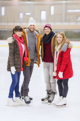 Vier Freunde mit Schlittschuhen auf dem Eis