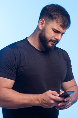 Mann, der nach SMS von Ex skeptisch aufs Handy schaut