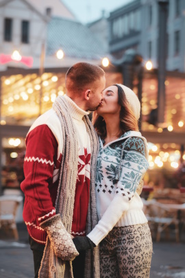 Mann und Frau küssen sich auf dem Weihnachtsmarkt