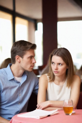 Unzufriedene Frau sitzt mit Mann im Café beim Date