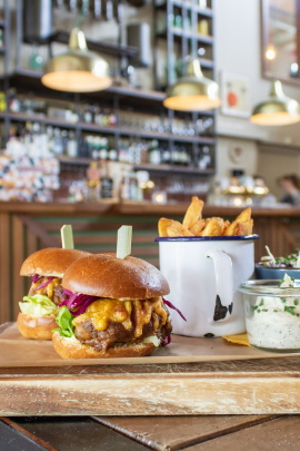 Bild mit zwei Burgern und Pommes in einem Restaurant