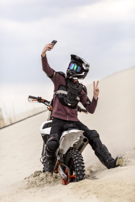 Mann macht Selfie auf dem Motorrad in der Wüste