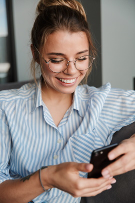 Lächelnde Ex-Freundin liest Nachricht am Handy
