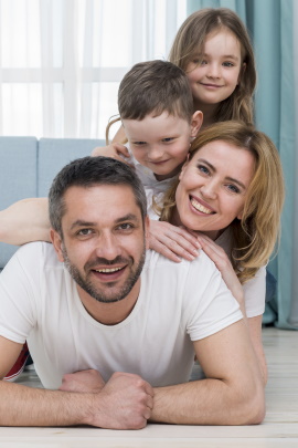 Glückliche Familie sitzt im Wohnzimmer auf dem Boden