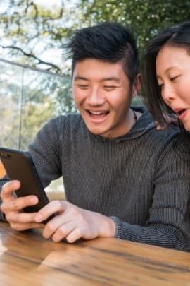 Mann und Frau probieren Facebook-Dating aus und haben Spaß dabei