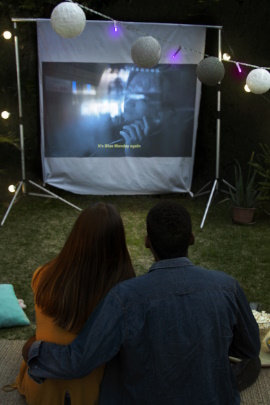 Paar macht Open-Air-Kino und schaut auf die Leinwand