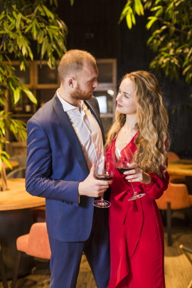 Mann und Frau mit Rotwein auf Gartenparty