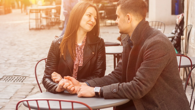 Paar stellt sich Fragen zum kennenlernen beim Date im Café