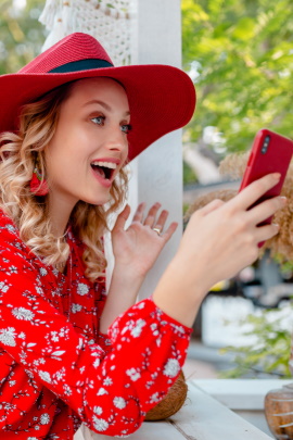 Interessierte Frau schaut lachend aufs Handy