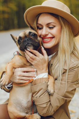 Frau kuschelt draußen mit süßem Hund