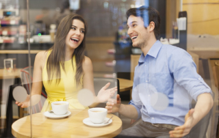 Mann bringt Frau zum Lachen im Café