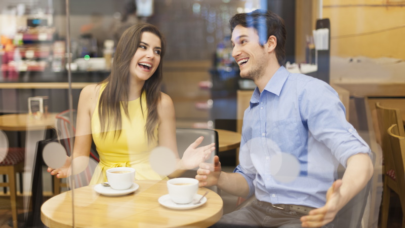 Mann bringt Frau zum Lachen im Café