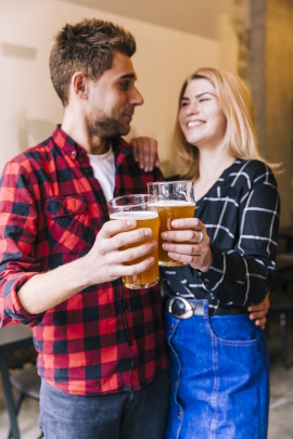 Fröhliches Paar stößt mit Glas Bier auf die Freundschaft an