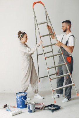 Mann und Frau tragen eine Leiter zum Anstreichen der Wohnung