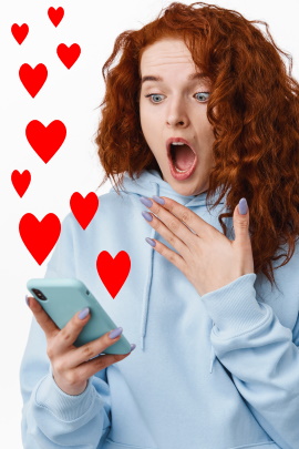 Frau blickt schockiert aufs Handy, wo Herzen aufsteigen