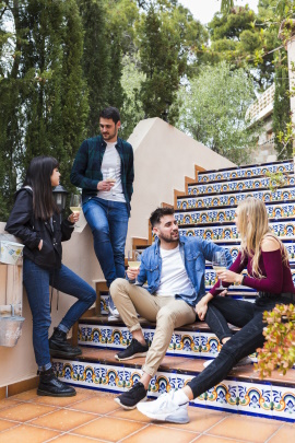 Zwei befreundete Paare unterhalten sich draußen auf einer Treppe