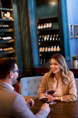 Mann und Frau mit Rotwein beim Date in einer Bar